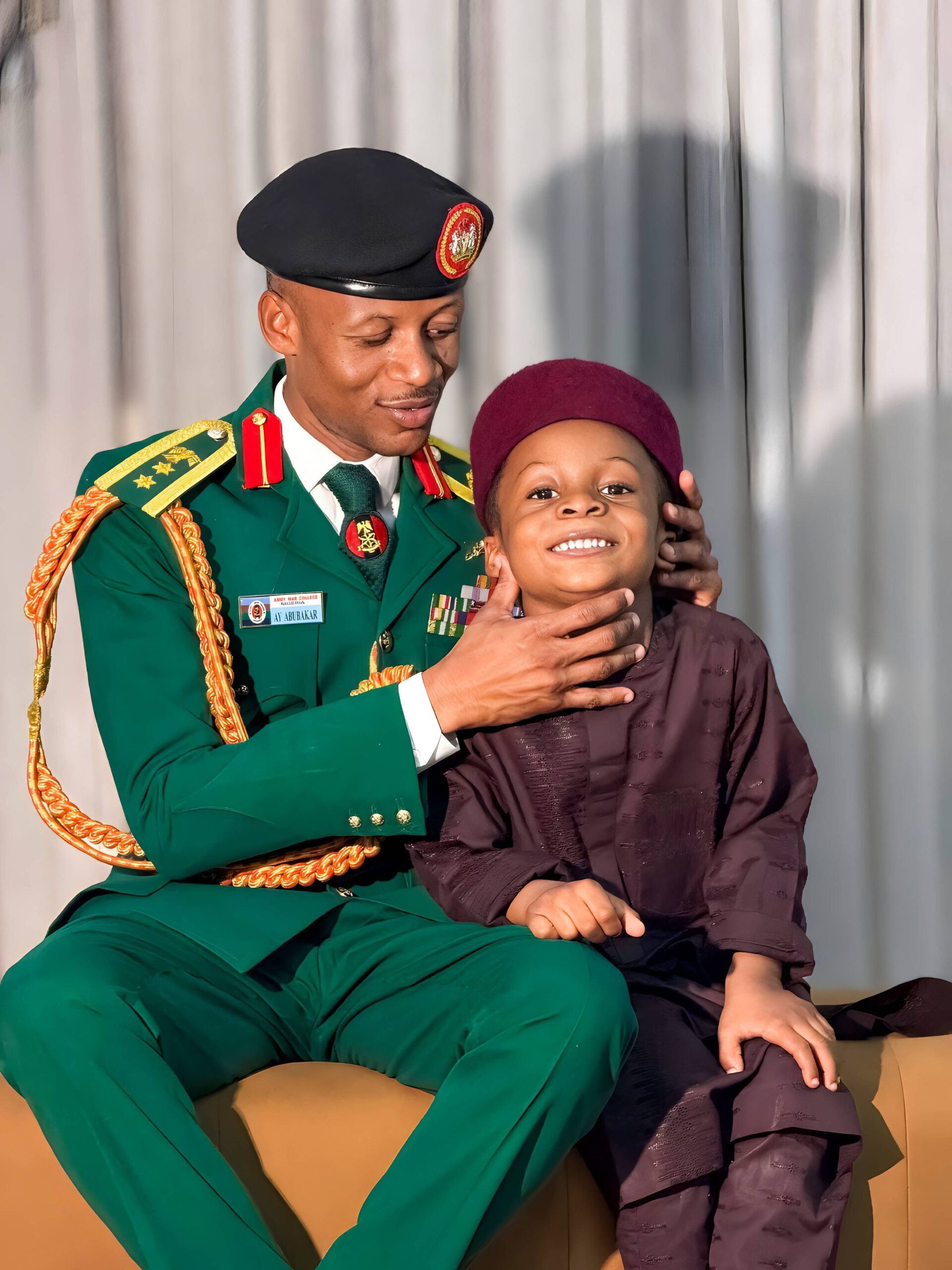 Smiling soldier in uniform bonding with son indoors.